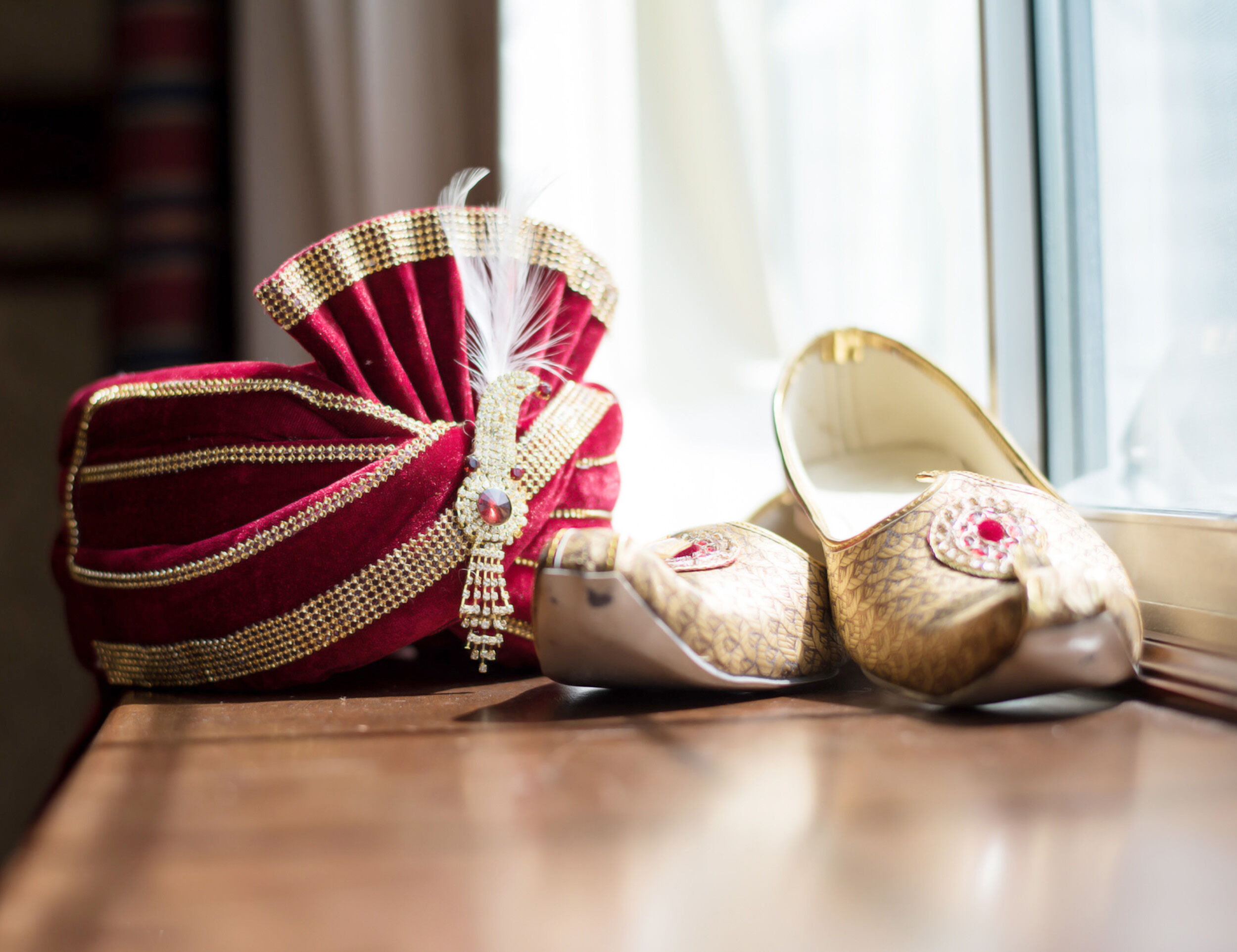 A beautifull red safa with white juttis for groom